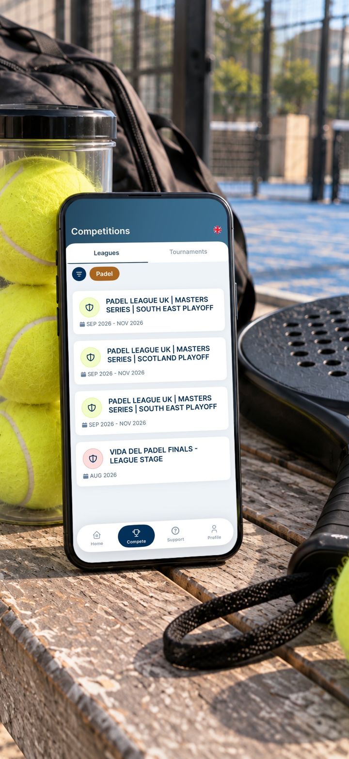 The Competitions screen of the Padel League UK app, listing leagues, on a phone resting on a bench next to padel balls and a racket.